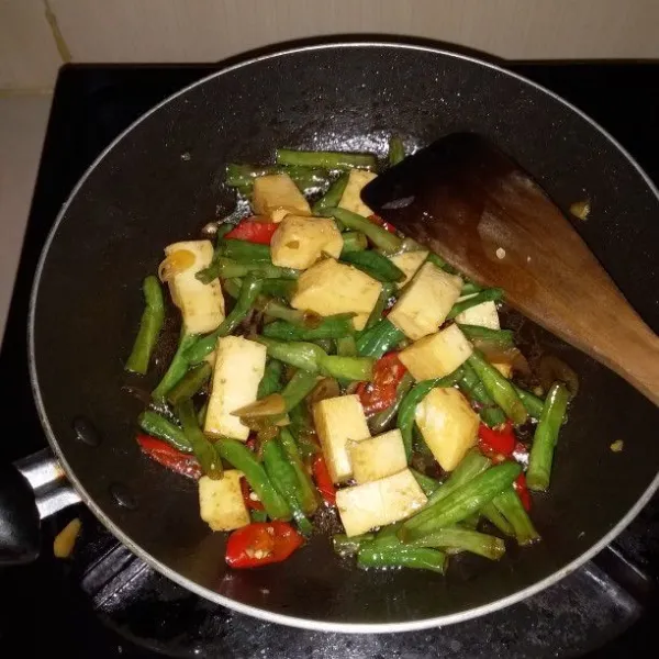 Tambahkan saus tiram, kecap manis, garam, gula, dan kaldu bubuk. Setelah kacang panjang layu, matikan api.