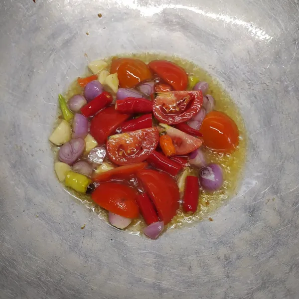 Goreng cabai merah, cabai rawit, bawang merah, bawang putih, dan tomat sampai layu. Kemudian pindah ke cobek.