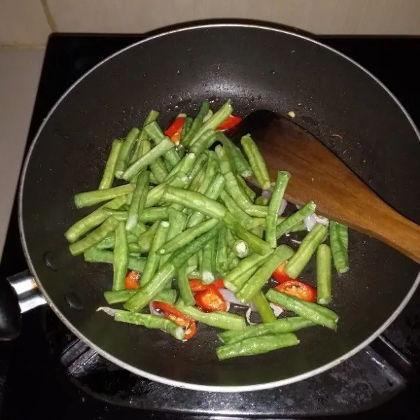 Panaskan minyak goreng. Tumis bumbu rajang hingga harum. Masukkan kacang panjang.