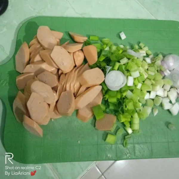 Iris sosis dan potong-potong daun bawang.