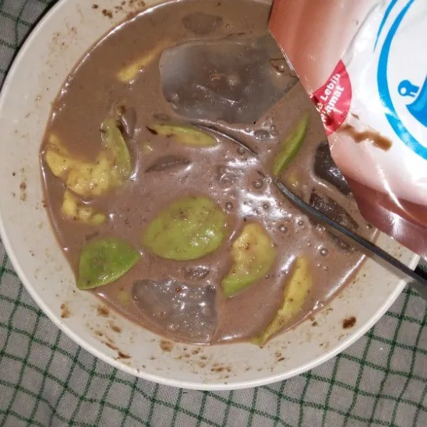 Tuang susu kental manis. Aduk hingga susu larut.