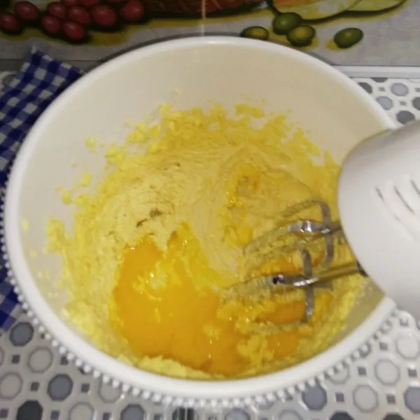 Masukan gula halus, margarin, soda kue, baking powder dan kuning telur dalam wadah. Kemudian mixer hingga mengembang