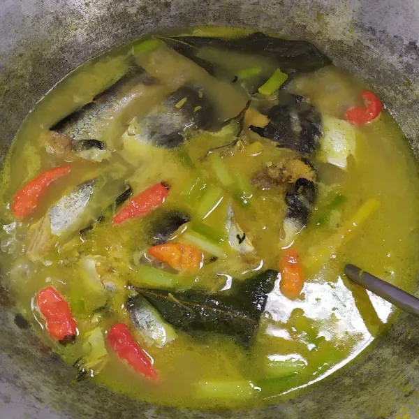 Masukkan cabai rawit dan daun bawang, biarkan hingga kuah keluar minyak, baru matikan kompor dan asem asem ikan patin siap disajikan.