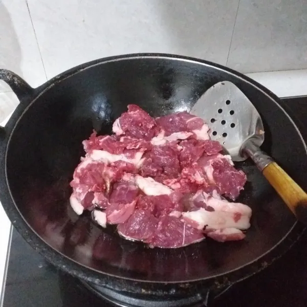 Panaskan minyak secukupnya, goreng daging kambing sampai empuk, jangan terlalu kering.