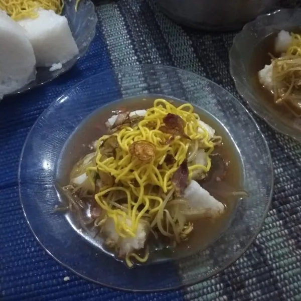 Lalu tambahkan kuah, beri potongan lontong, tambahkan sayur cambah dan mie basah. Taburi dengan bawang goreng. dan sajikan