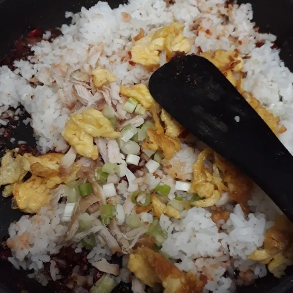 Masukkan nasi putih, daun bawang, orak- arik telur, dan ayam suwit. Aduk-aduk hingga rata lalu cek rasa.