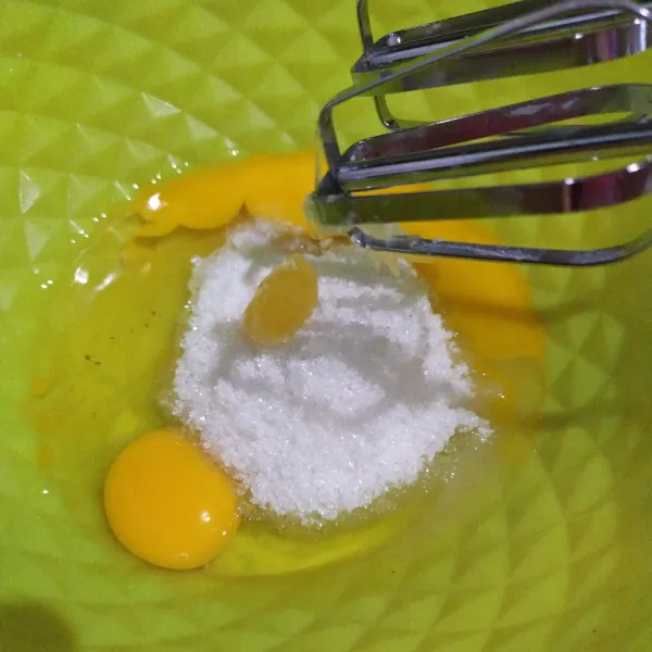 Dalam wadah masukkan dua butir telur, gula pasir, SP, garam, dan vanili bubuk. Mixer hingga putih pucat dan berjejak kurang lebih 7 menit.