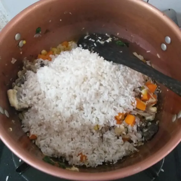 Masukkan beras, aduk terus selama kurang lebih 3 menit. Proses ini yang akan membuat beras menjadi lebih lezat karena bumbu yang meresap.