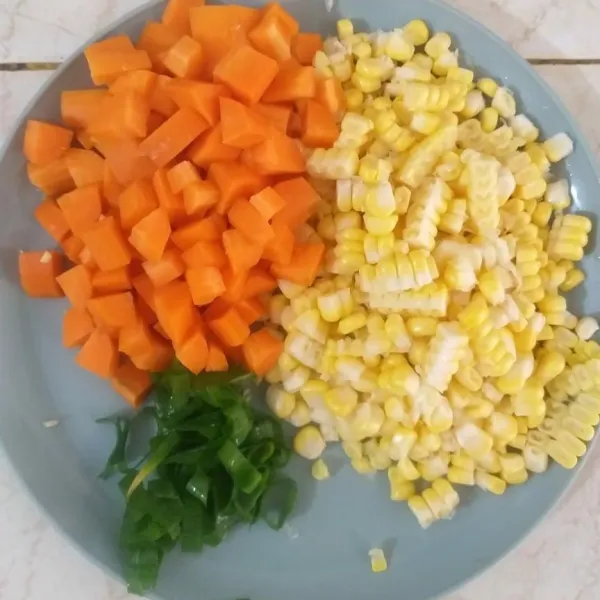 Potong dadu wortel dan pipil jagung, lalu potong tipis-tipis bawang prei.