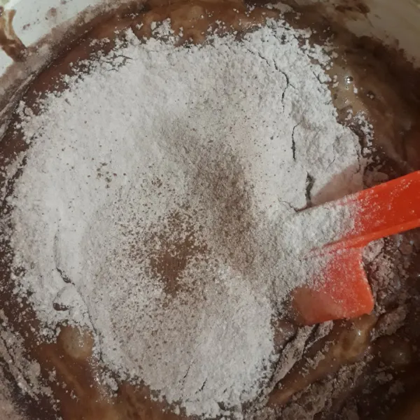Masukan tepung terigu dan coklat bubuk. Aduk rata. Tidak usah terlalu lama mengaduknya, yang penting tercampur rata