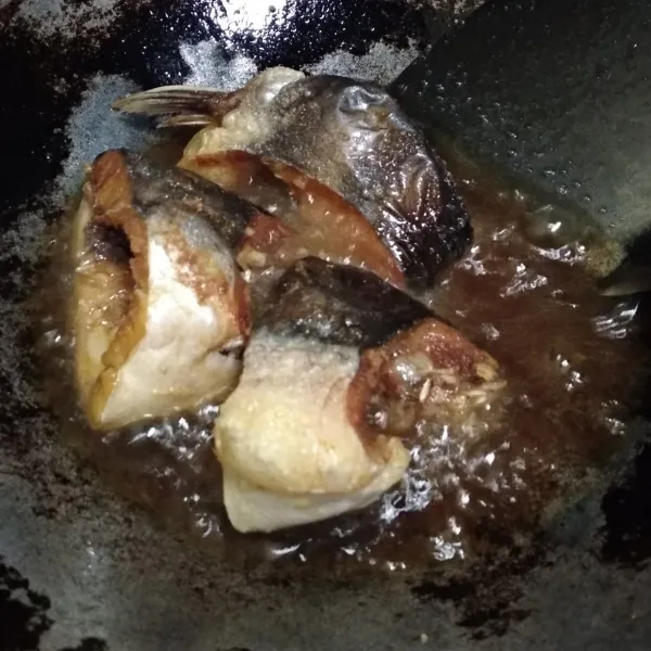 Goreng ikan patin yang sudah dibersihkan dan dimarinasi dengan garam dan jeruk nipis.