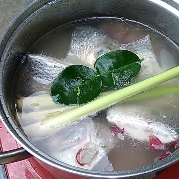 Tambahkan air asam jawa, serai dan daun jeruk ke dalam ikan. Masak sampai serai mulai layu dan air menjadi kaldu.