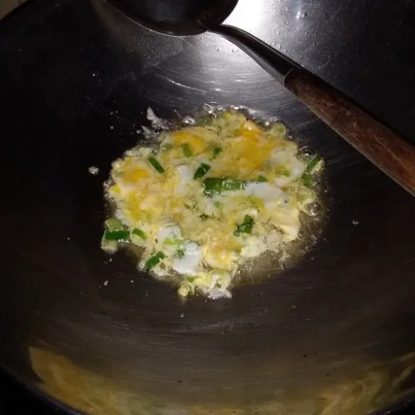 Panaskan minyak baceman bawang putih. Tumis daun bawang hingga layu. Ceplok telur kemudian orak-arik hingga matang.