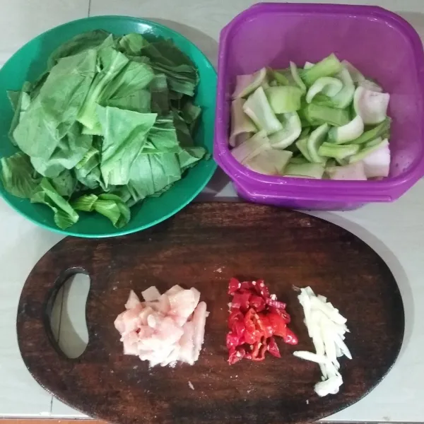 Potong-potong baby pakcoy, pisahkan daun dan batangnya. Iris juga bahan lainnya.