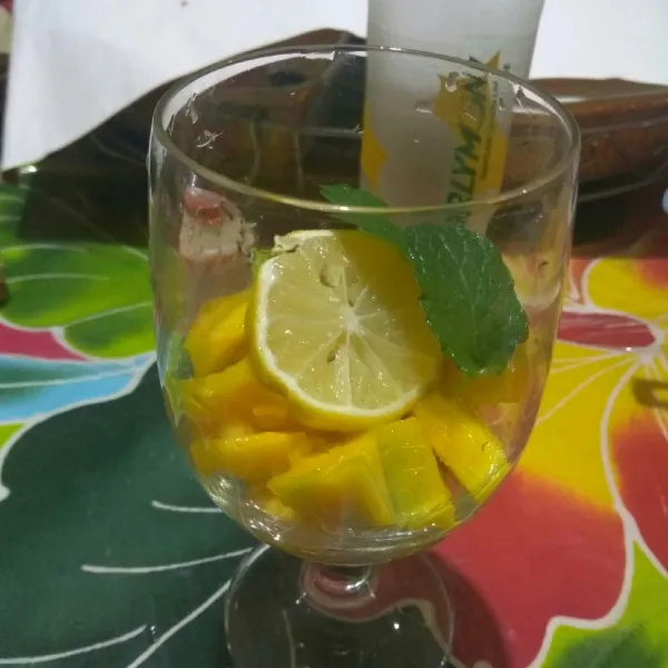 Masukan mangga dan potongan lemon ke gelas.