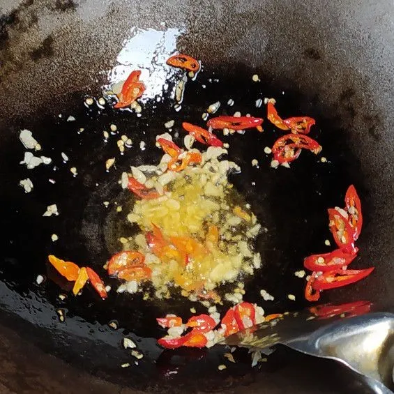 Tumis bawang putih, cabai merah besar dan cabai rawit dengan secukupnya minyak goreng hingga harum.