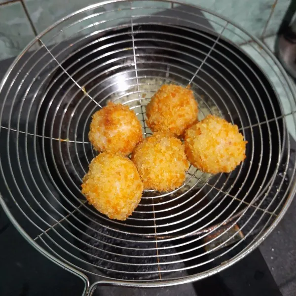 Goreng bola- bola nasi liwet hingga kuning keemasan. Tata di piring, beri topping sayur dan sambal cumi.