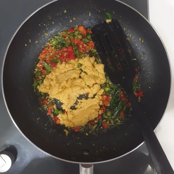 panaskan margarin, tumis bawang putih cincang sampai harum, masukan semua cabai,dan Daun Kari Aduk rata,tumis sebentar, masukan kuning telur asin yang telah di blender halus, Aduk rata.