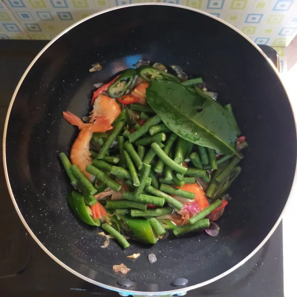 Masukan kacang panjang dan daun salam, masak hingga agak layu.