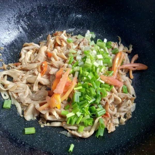 Masukkan irisan tomat dan daun bawang. Tumis sebentar saja.
