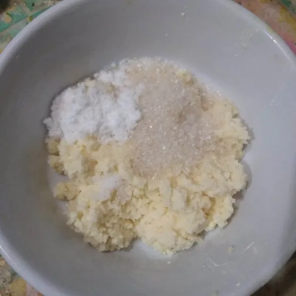 Taruh singkong parut di mangkok, tambahkan bawang putih bubuk, gula pasir dan garam, aduk rata.