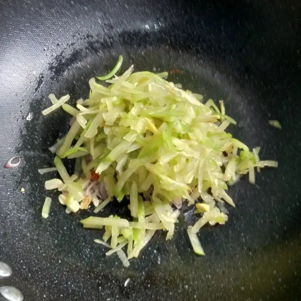 Masukkan labu siam. Tumis setengah matang lalu tambahkan air, gula, garam, kaldu bubuk, dan juga kecap manis.