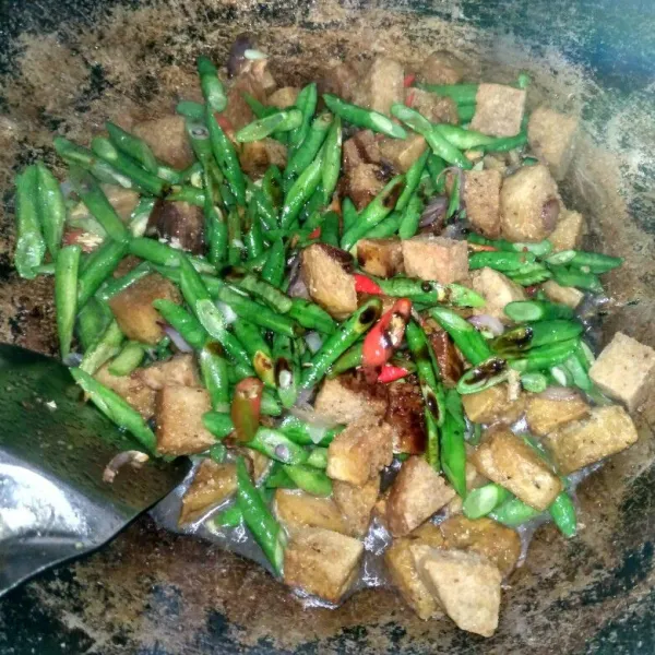 Masukkan tempe, kacang panjang, cabai, dan kecap manis. Lalu aduk rata.
