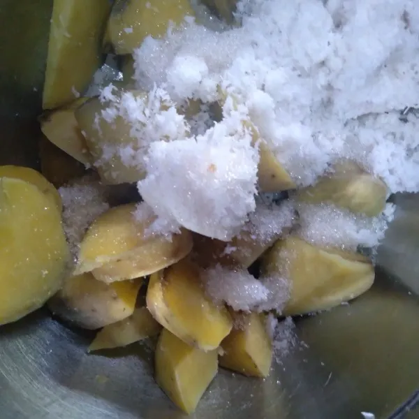 Setelah empuk masukkan potongan ubi kukus selagi hangat dan kelapa parut di baskom. Beri gula pasir.