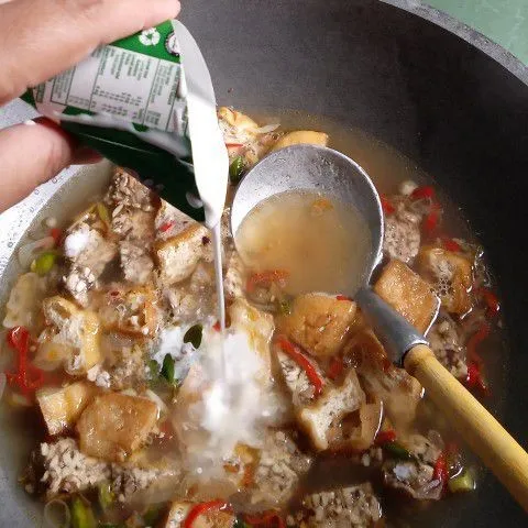 Tuang santan dan masak sampai mendidih, sesekali diaduk agar santan tidak pecah.