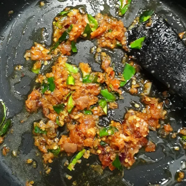 Tumis bumbu halus dan daun jeruk dengan memakai minyak bekas untuk menggoreng ikan teri asin hingga harum