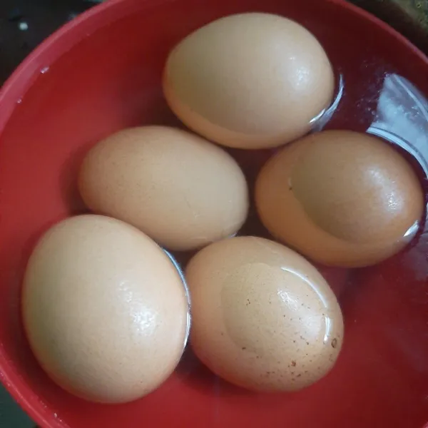 Rebus 5 butir telur selama 7 menit dengan api sedang. Kemudian tiriskan, masukkan ke dalam air dingin.