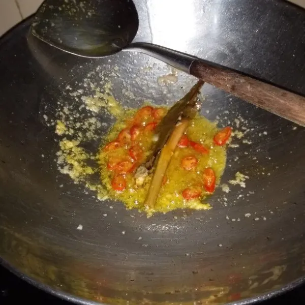 Panaskan minyak goreng. Tumis bumbu halus, daun salam, batang serai, lengkuas, irisan cabai, dan kunyit bubuk hingga harum.