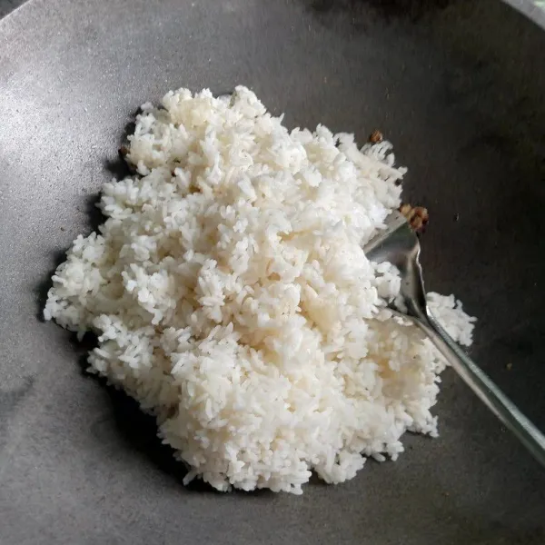 Masukan nasi putih, aduk rata. Goreng sampai cukup matang dan cek rasa.