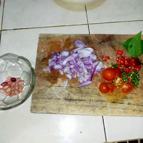 Iris tipis-tipis bawang merah, cabe merah keriting, cabe rawit. Belah dua tomat ceri serta rajang kasar kacang tanah goreng dan kemangi.
