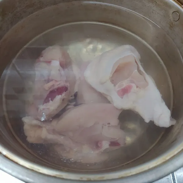 Potong ayam menjadi 4 bagian, rebus bersama air sampai mendidih, sambil siapkan bumbu soto.