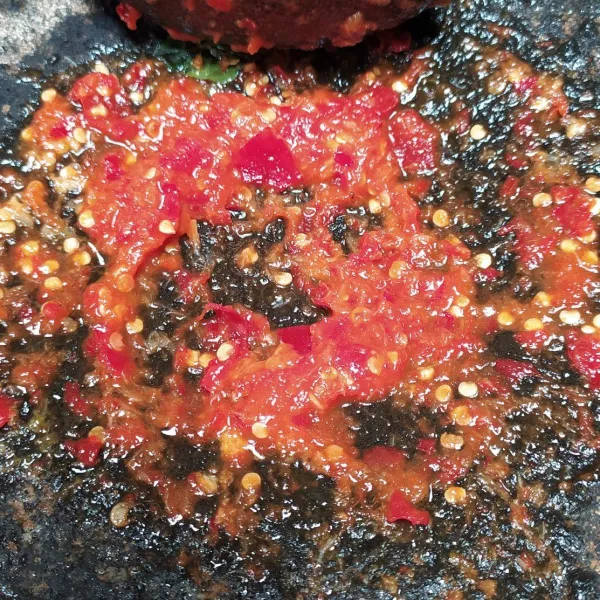 Uleg bahan sambal kencur, lalu tuangi minyak goreng panas. Ratakan.