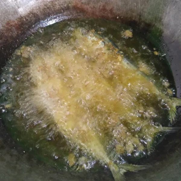 Goreng ikan di dalam minyak panas sampai matang kering.