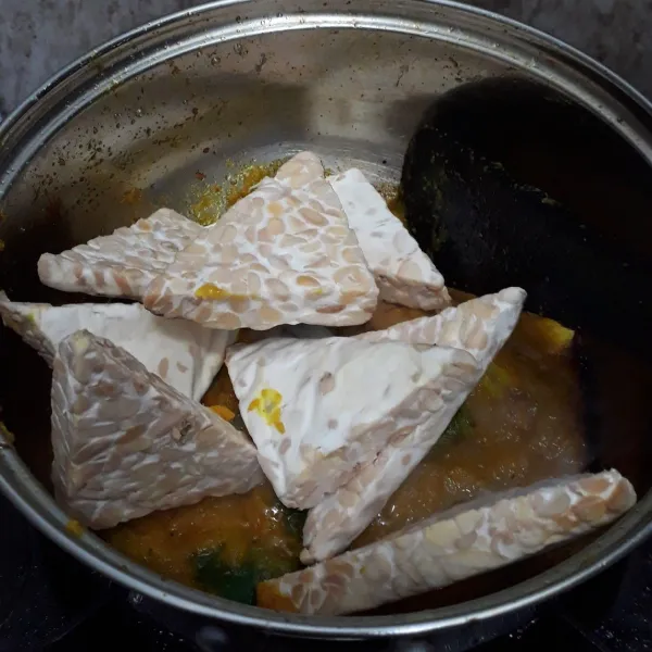 Masukkan tempe, garam, gula merah dan air lalu aduk rata.  Didihkan lalu kecilkan api. Masak hingga bumbu meresap ke dalam tempe.