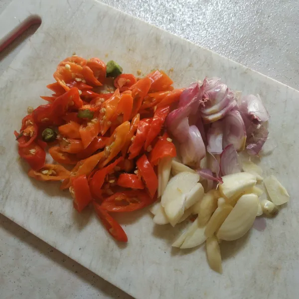 Potong cabai rawit, bawang putih, dan bawang merah.