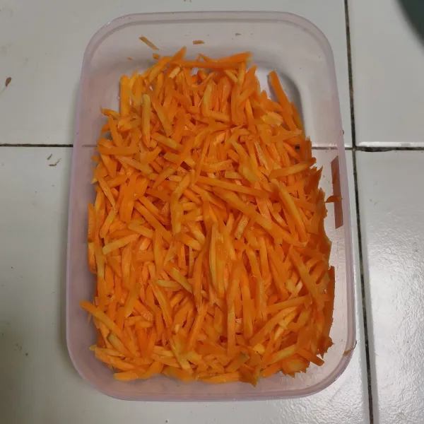Kupas dan cuci bersih wortel. Parut kecil dengan parutan sayur. Sisihkan.