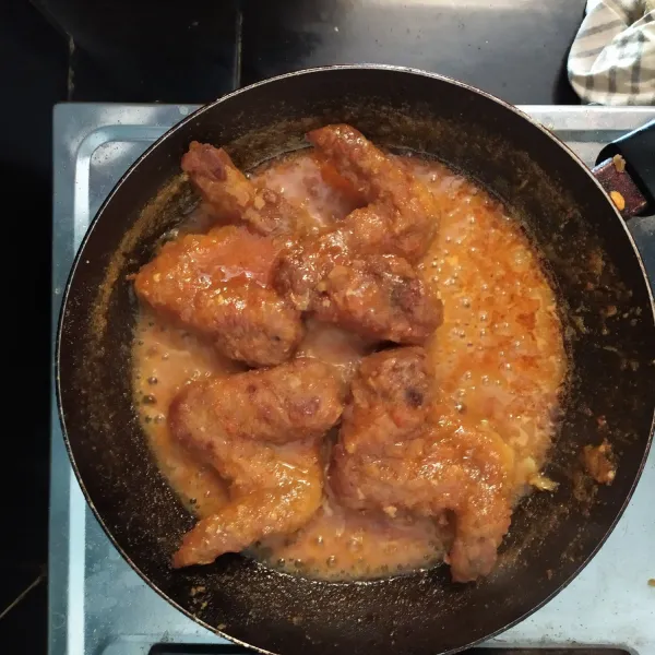 Lalu masukkan ayam dan tunggu hingga bumbunya meresap ke dalam ayam.  Setelah itu letakkan sayap ayam di atas piring dan beri hiasan.