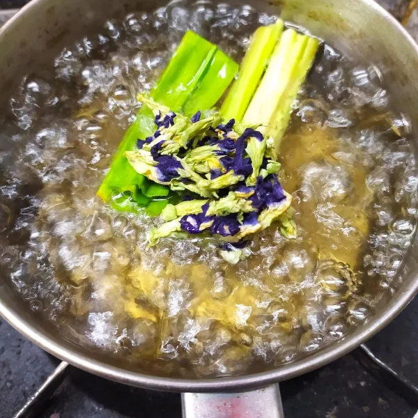 Masukkan bunga telang. rebus sebentar kemudian matikan kompor. biarkan sampai dingin dan air berwarna biru. kemudian saring airnya.