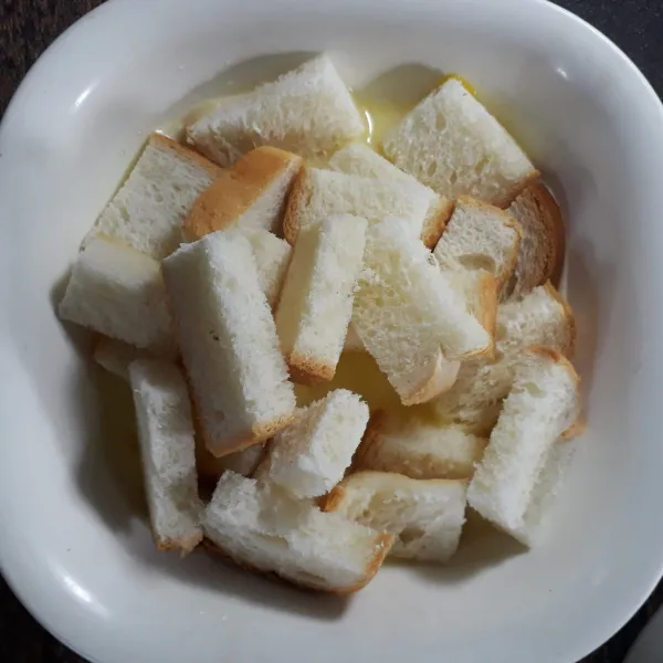 Masukkan potongan roti tawar ke dalam mangkuk yang berisi adonan telur santan. Aduk dan agak ditekan pelan sampai roti tawar menyerap cairannya. Sisihkan.