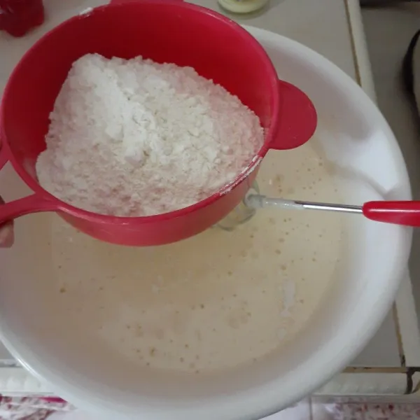 Kemudian masukan terigu, garam dan baking powder lalu ayak, aduk rata.