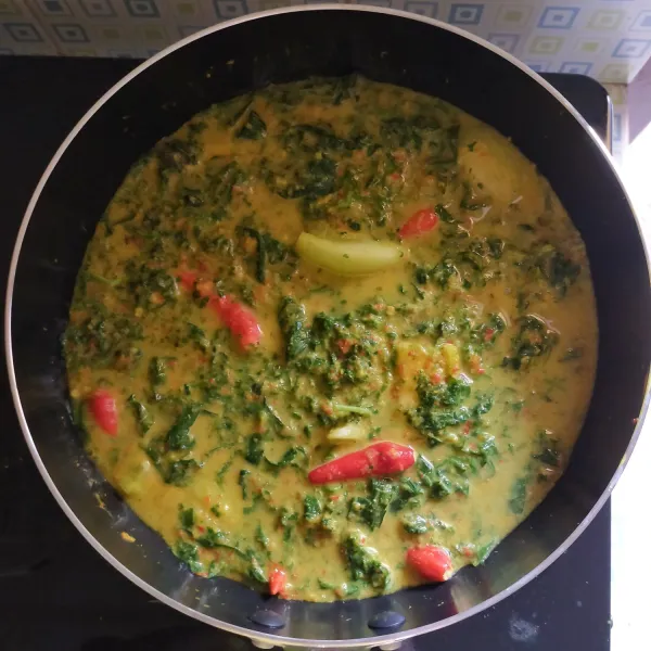 Masak dengan api sedang hingga daun singkong lembut. Setelah mendidih dan lembut, angkat dan sisihkan.