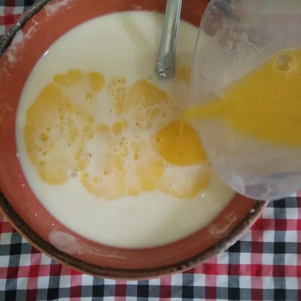 Tuang telur kocok ke dalam adonan tepung, aduk rata.