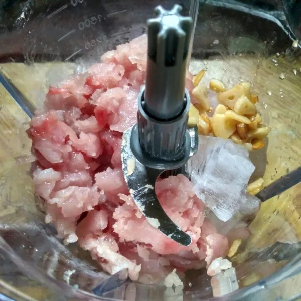 Masukan daging ikan, putih telur, es batu dan bawang putih kedalam chooper.