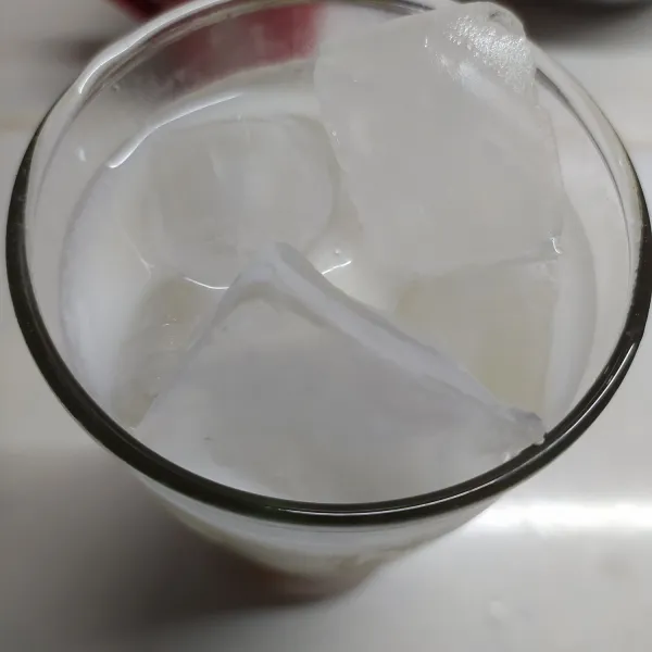 Beri es batu sampai hampir penuh tinggi gelas, beri susu cair sampai hampir penuh.