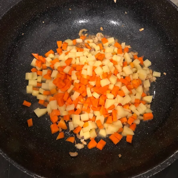 Masukan kentang dan wortel lalu tumis sebentar hingga harum.