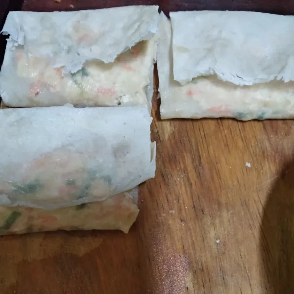 Ambil 1 lembar kulit lumpia dan beri 1 sendok makan adonan isian. Lalu lipat.